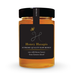 Jar of Honey Hasapis raw thyme honey with a black label on a white background